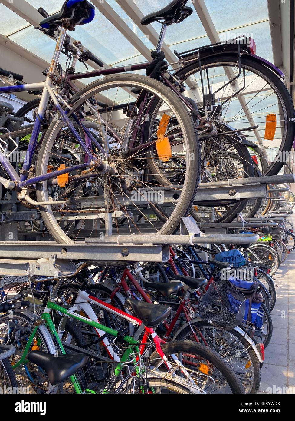 Überfülltes öffentliches Parkhaus für Fahrräder unter einem Vordach. Stockfoto