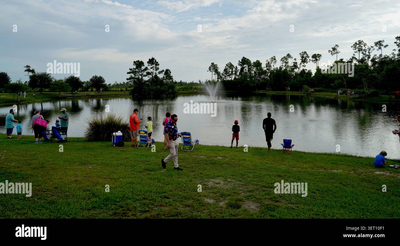 Panama City, FL, USA. Juni 2026. Familien säumen das Ufer des Callaway Children's Fishing Pond, einem sprudelnden Brunnen, der mitten im Wasser sprüht, während Angler während des 23. Jährlichen Callaway Children's Fishing Rodeo ihre Leinen ziehen. Das kostenlose Vatertag-Wochenende, das von City of Callaway Leisure Services veranstaltet wird, steht Teilnehmern bis 16 Jahren in Begleitung eines Erwachsenen offen. Fish Florida spendete den ersten 200 Kindern kostenlose Ruten- und Walzenkombinationen, wobei die größten Fisch- und Verlosungspreise am Vormittag verliehen wurden. Quelle: Tosh Persons / Alamy Live News Stockfoto