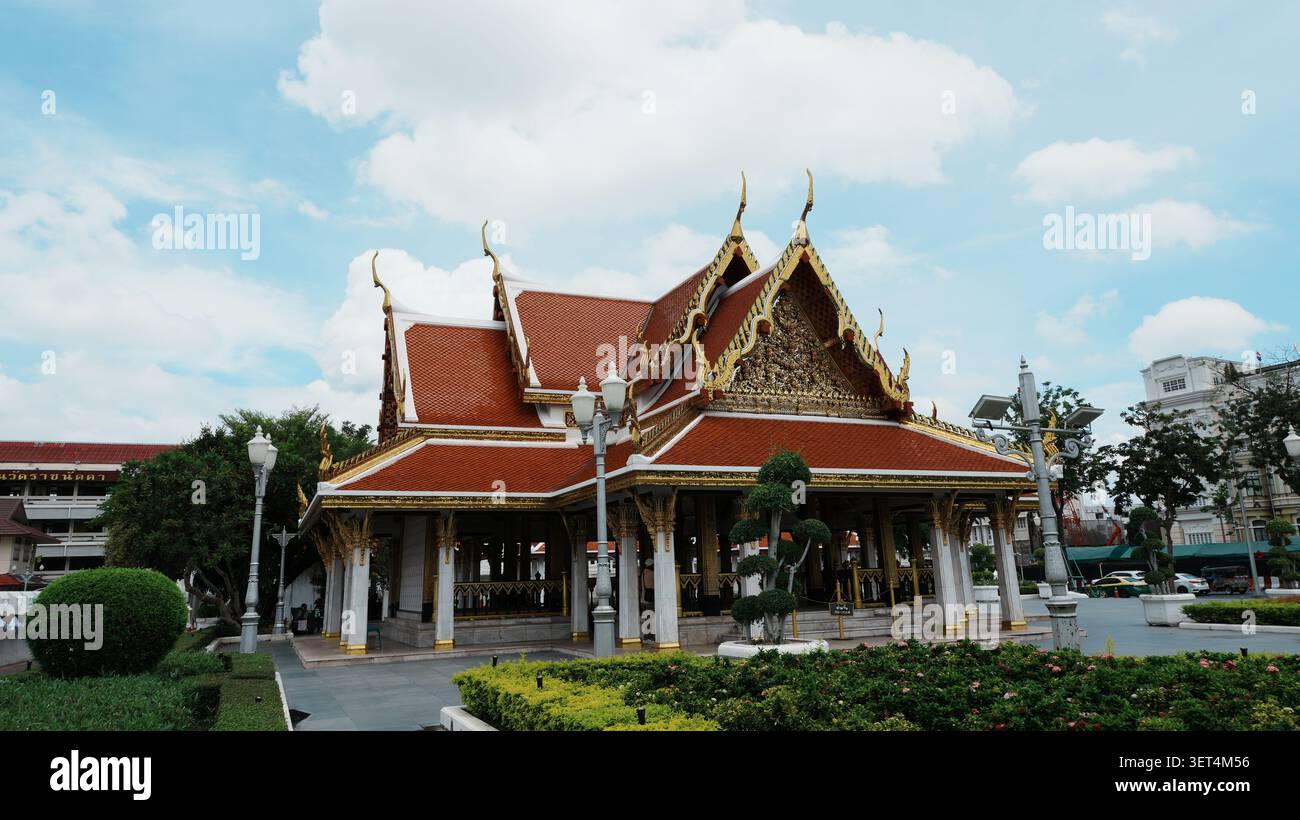 Breite Front Mit Vollem Blick Auf Traditionelle Thailändische Tempelhalle, Rotes Fliesendach, Goldenes Vergoldetes Ornament Stockfoto