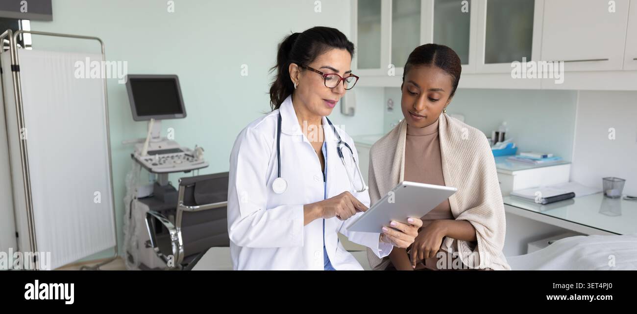 Ernsthafte erfahrene reife Ärztin, die den Patienten konsultiert Stockfoto
