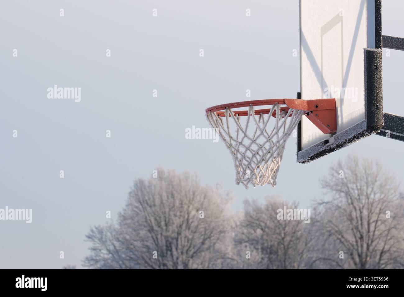 Frostbedeckter Basketballkorb auf einem Freiluftplatz im Winter in Lettland Stockfoto