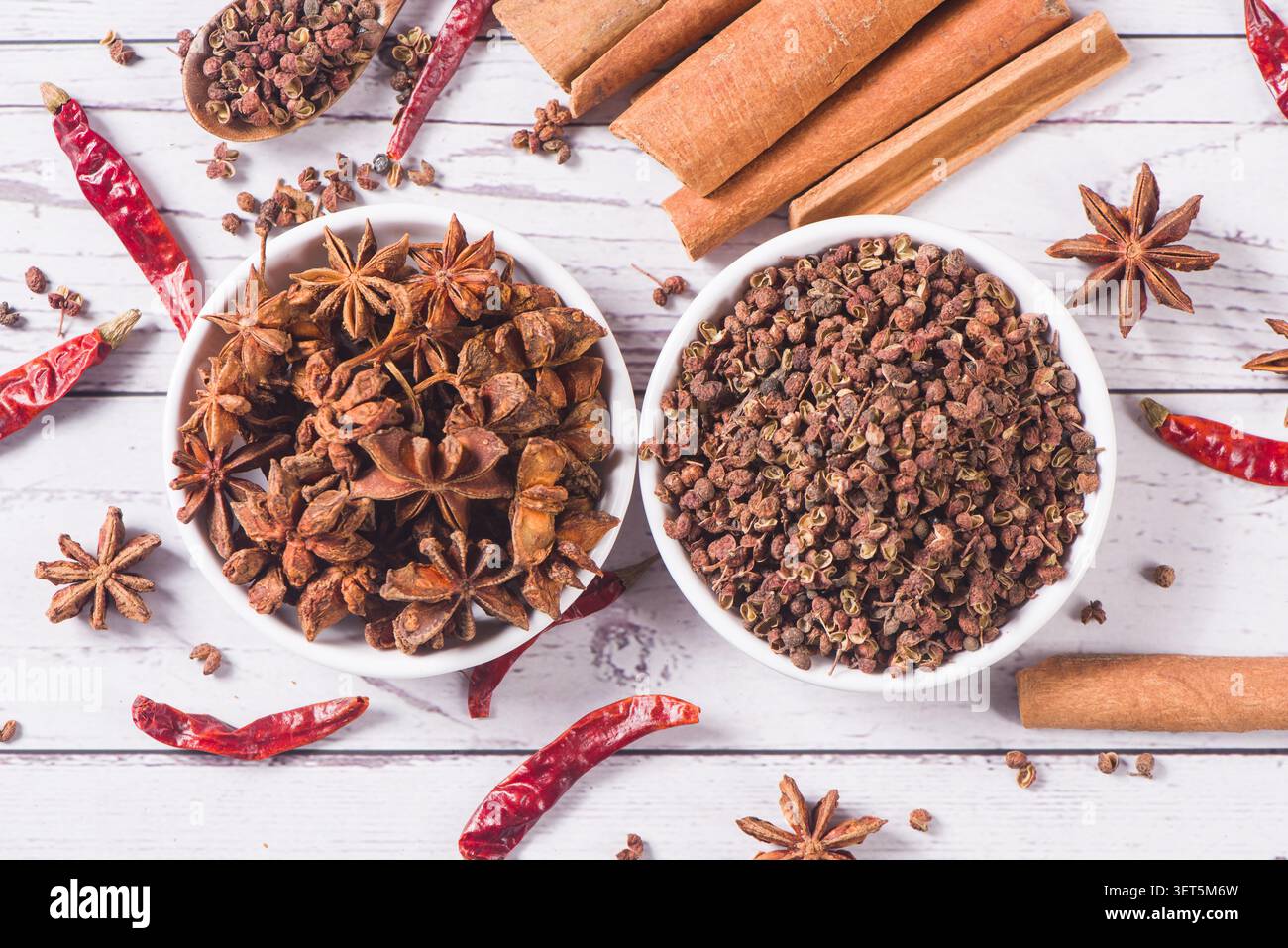 Verschiedene aromatische Gewürze und Kräuter auf einem rustikalen Holztisch Stockfoto