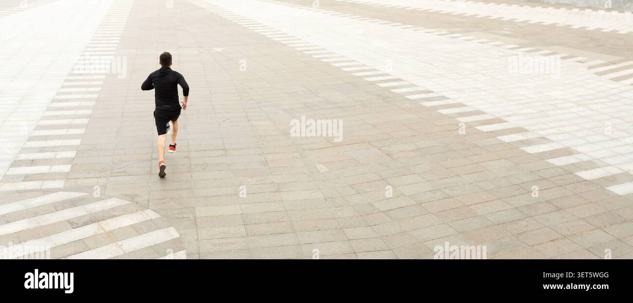 Läuferübungen auf leerem Gehweg während des bewölkten Tages an Urban Location Stockfoto