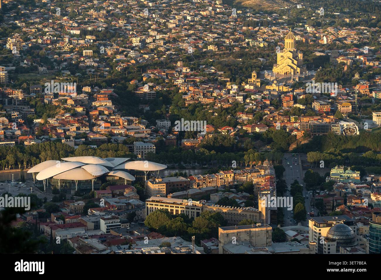 Aus der Vogelperspektive von Tiflis Stadt aus gesehen vom Mtatsminda Park in Georgien. Die goldene Kathedrale der Heiligen Dreifaltigkeit (Sameba) ist oben rechts zu sehen. Stockfoto