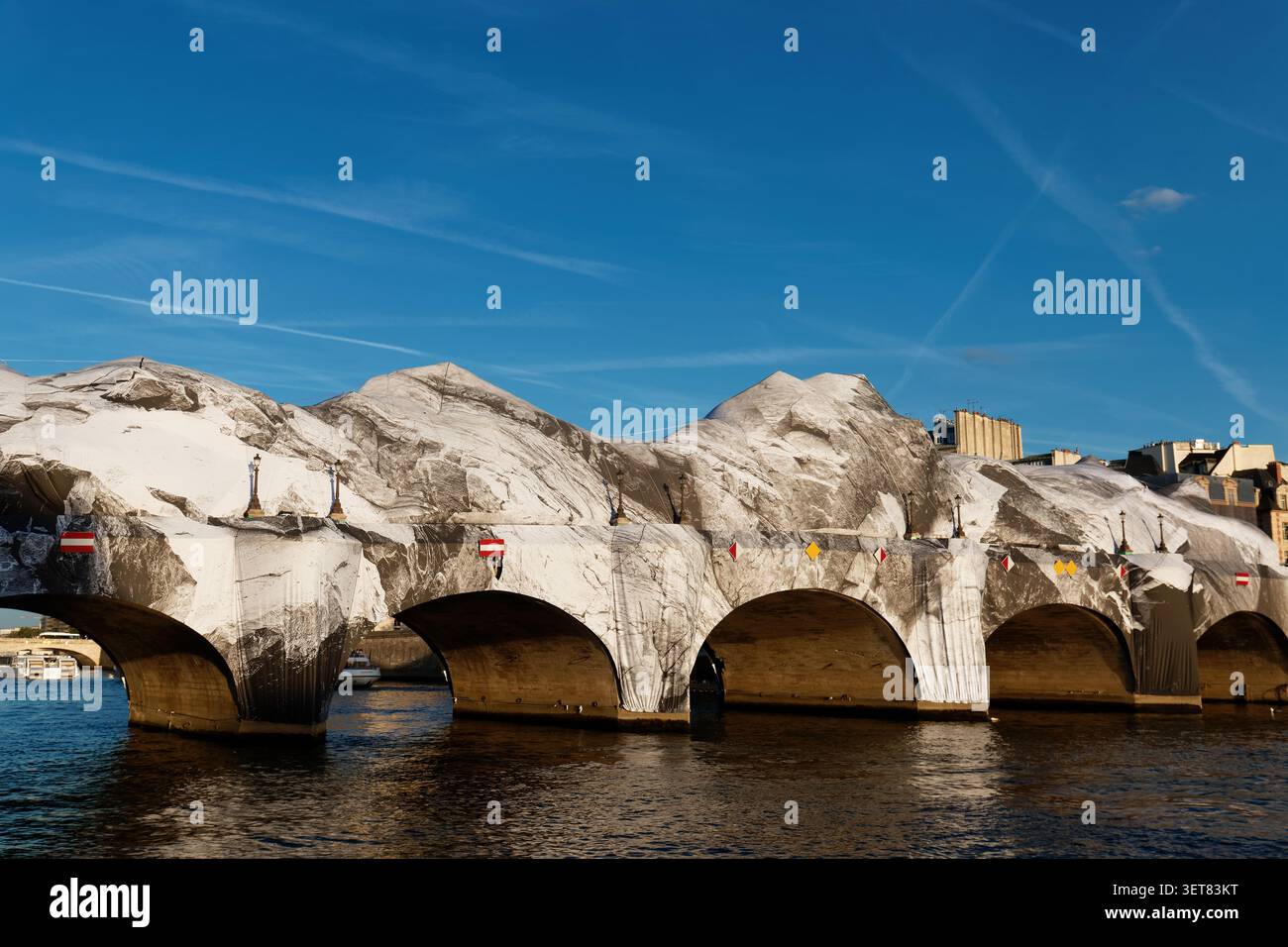 Paris, Frankreich - 17. Juni 2026: Das goldene Abendlicht taucht JR dramatische felsige Installation auf der Pont Neuf in Paris auf, die Bergstruktur leuchtet warm Stockfoto