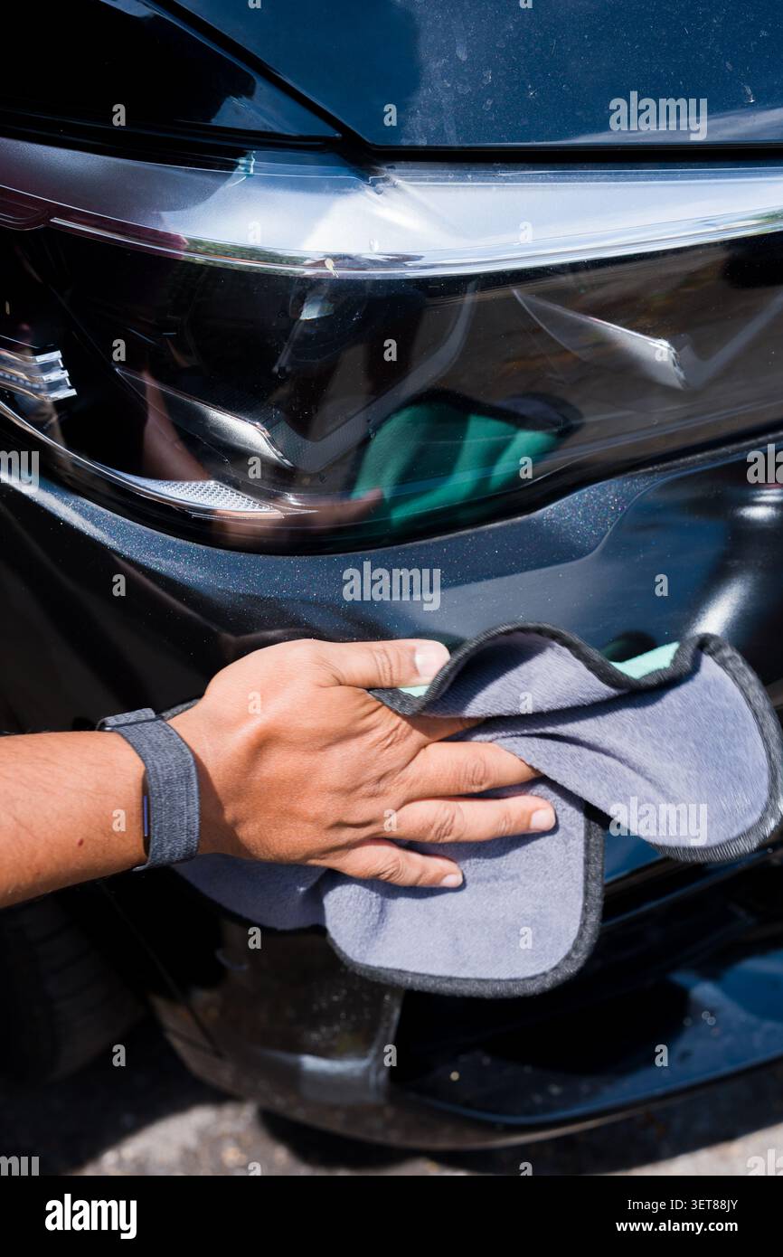 Reinigung der Fahrzeugoberfläche mit Mikrofasertuch während der Fahrzeugdetektierung Stockfoto