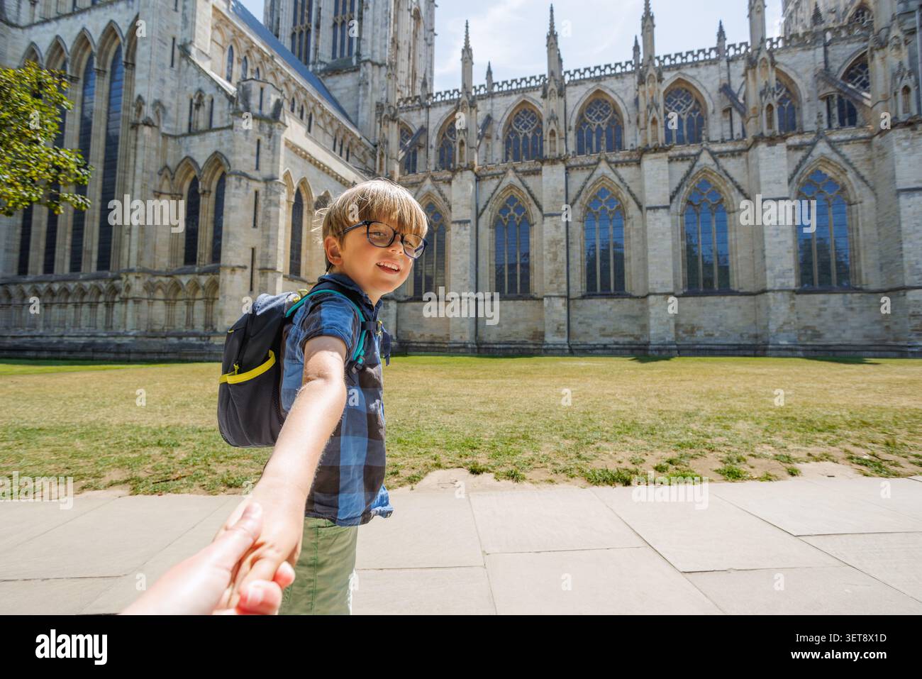 Junge mit Rucksack hält Hand vor York Minster, Großbritannien Stockfoto