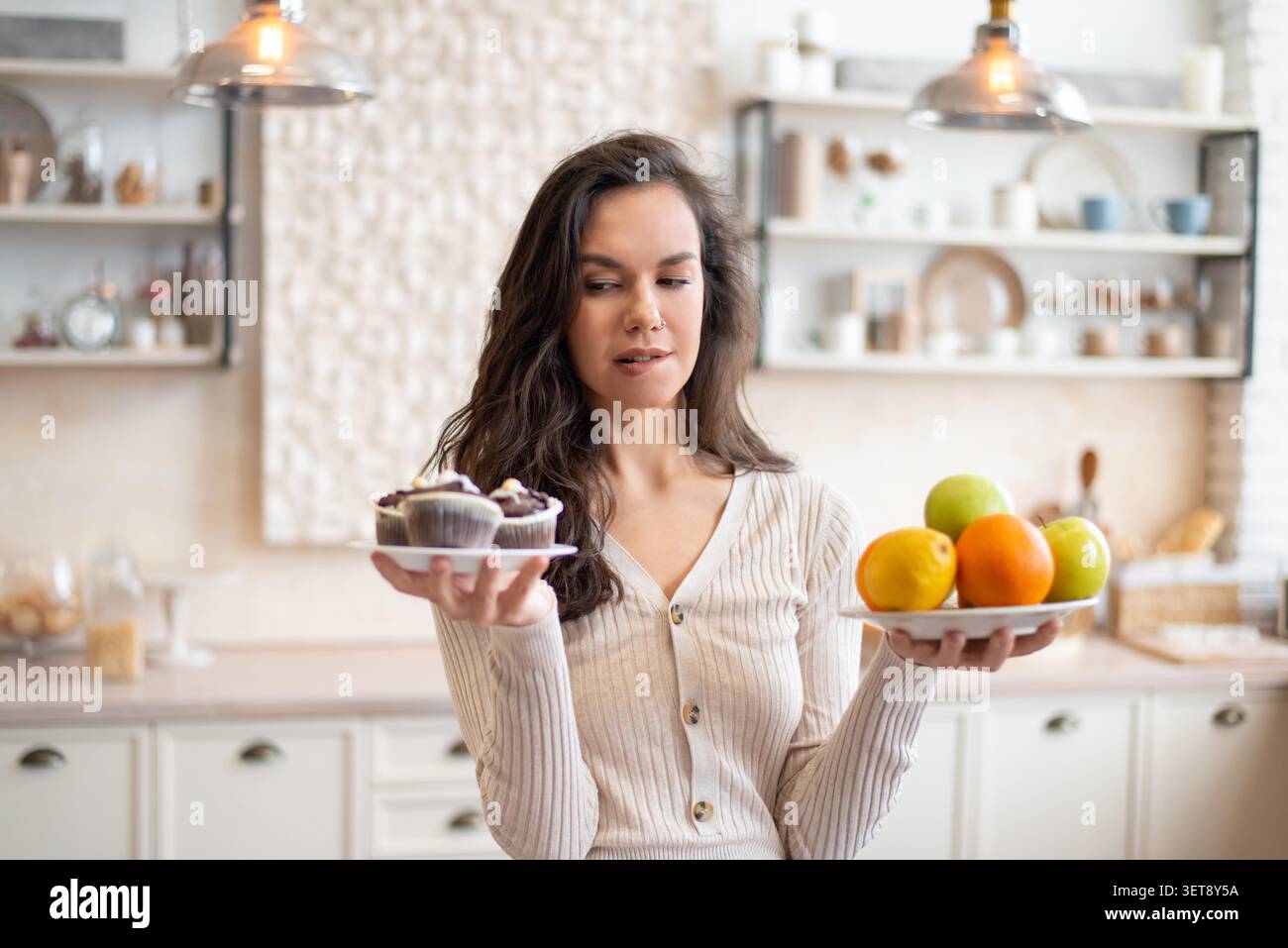 Frau Mit Gesundem Obst Und Süßem Gebäck In Der Küche, Konzentriert Auf Die Auswahl. Ernährungskonzept Stockfoto