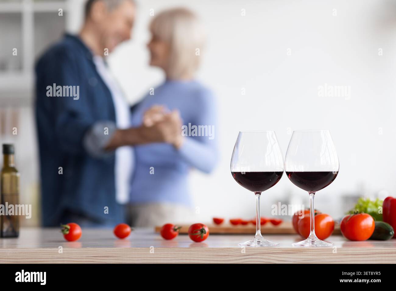 Unerkennbares Paar Tanzt Zusammen Mit Weingläsern In Der Modernen Küche, Glückliche Stimmung Stockfoto