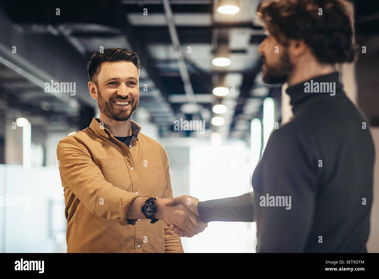 Ein Lächelnder Kaukasier Schüttelt Hand Mit Einem Kollegen In Modern Office, Business Concept Stockfoto