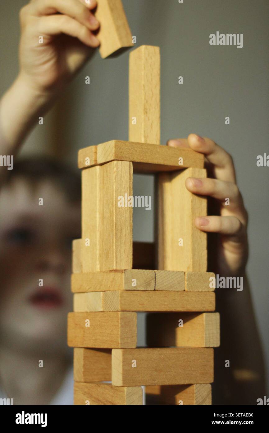 Ein Spiel mit Holzstöcken. Das Kind baut mit einem Kit. Kindliche Entwicklung Stockfoto