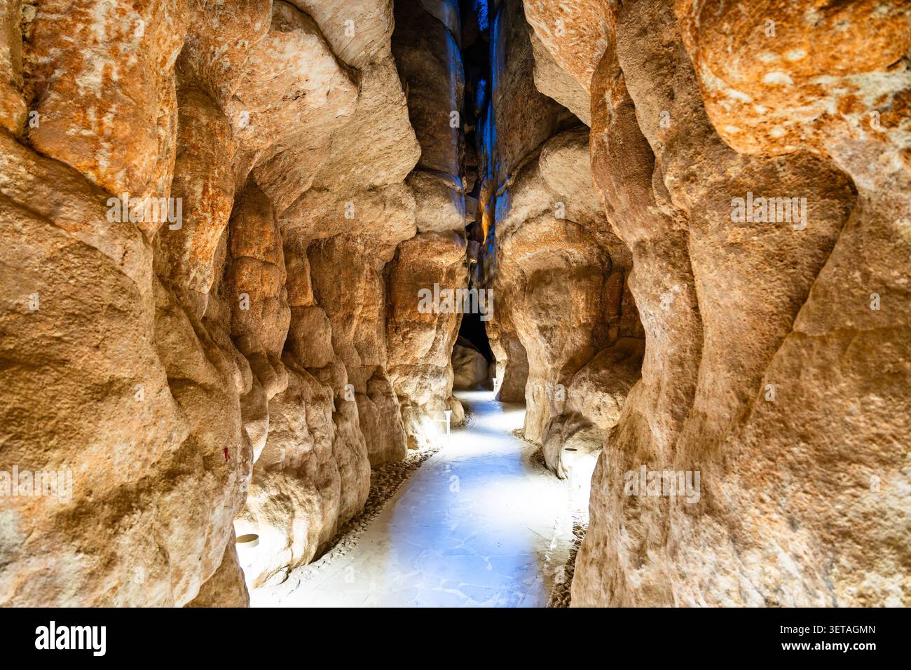 Ein malerischer beleuchteter Steinweg, der sich durch die engen Höhlen des Al Qarah-Berges in der Al Ahsa-Region Saudi-Arabiens schlängelt. Stockfoto