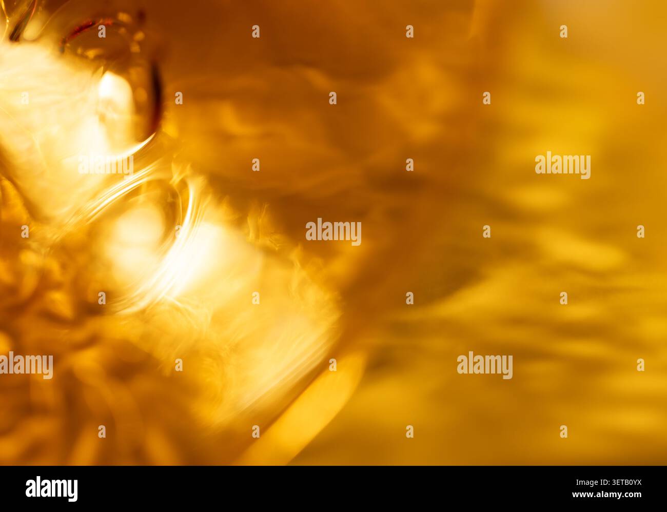 Goldene abstrakte Lichtreflexe mit warmen Gelbtönen und weicher Textur Stockfoto