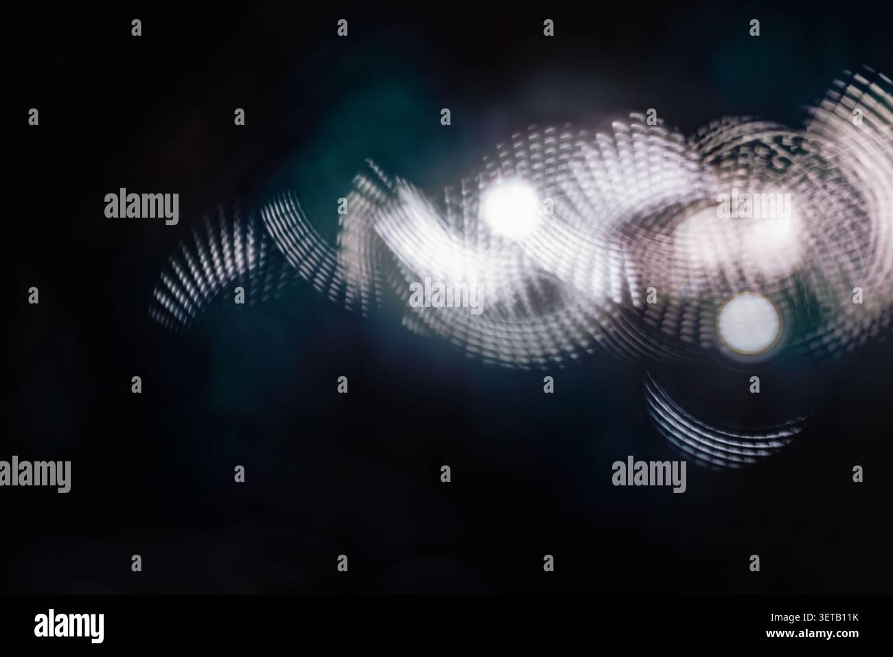 Weiß gepunktete helle Spur auf dunklem Hintergrund mit weichem Bokeh für futuristisches abstraktes Design Stockfoto