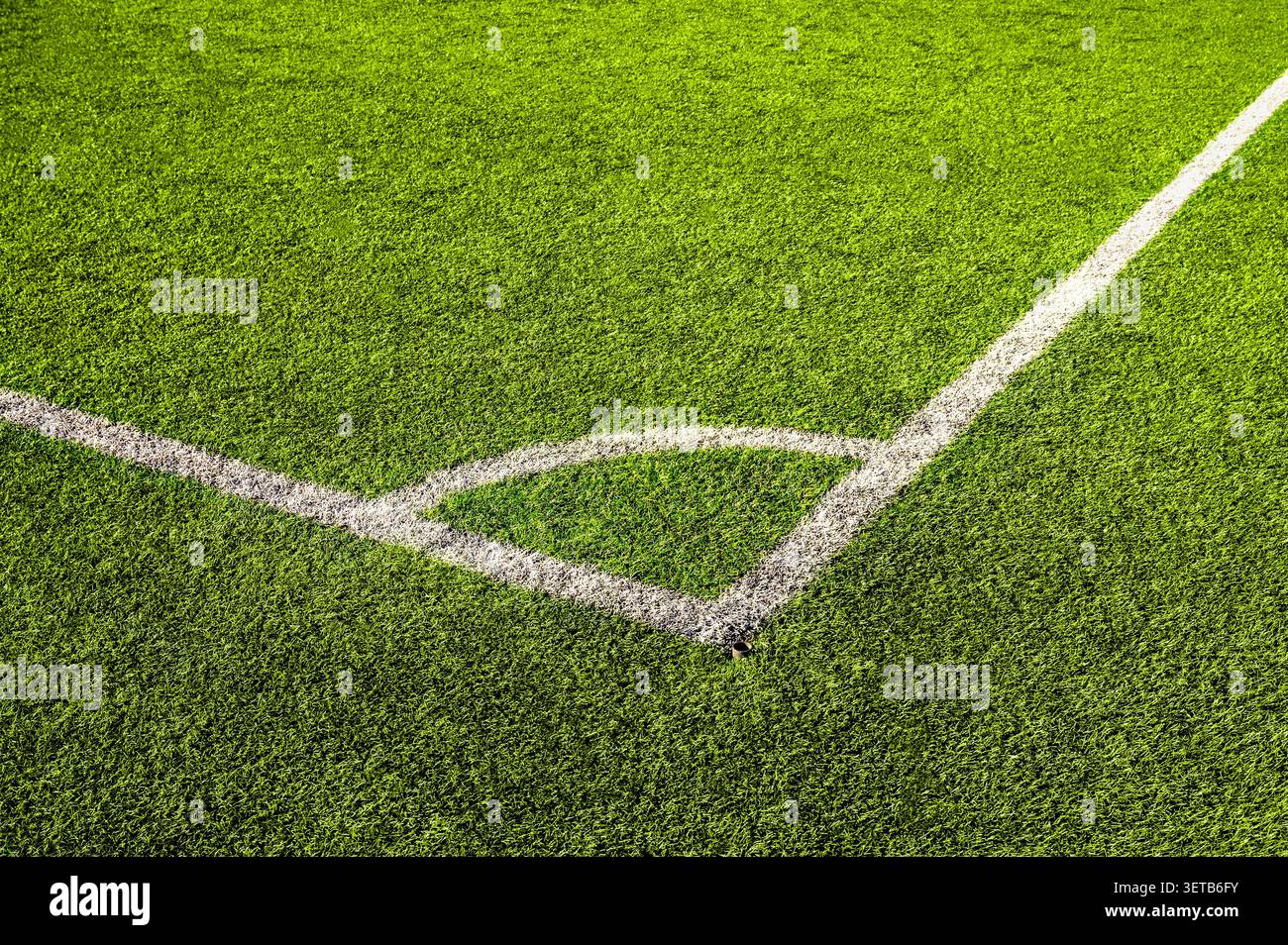 Blick von oben auf grünes Kunstrasen mit weißen Markierungslinien auf dem Fußballfeld. Kickbereich für Fußballplätze mit Kunstrasen. Stockfoto