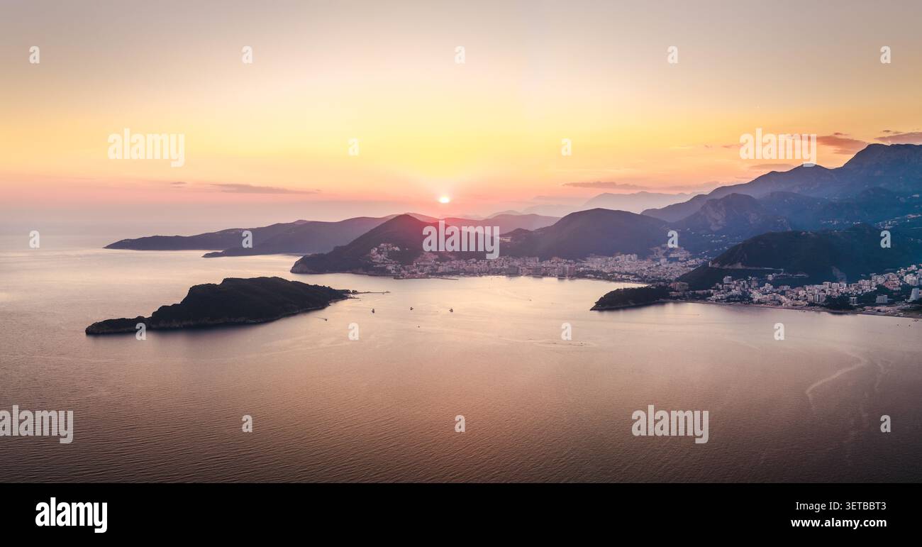 Panorama des Sonnenuntergangs über die Küste der Budva Riviera mit der Insel Sveti Nikola und der Adria in Montenegro Stockfoto