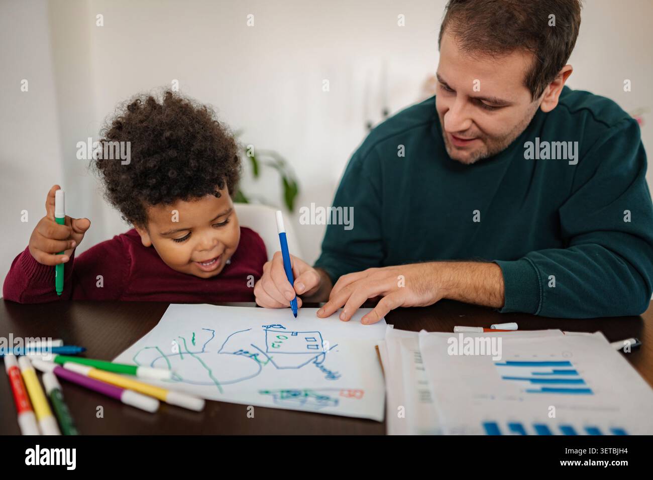 Vater und Sohn verbinden sich durch kreatives Zeichnen zu Hause Stockfoto