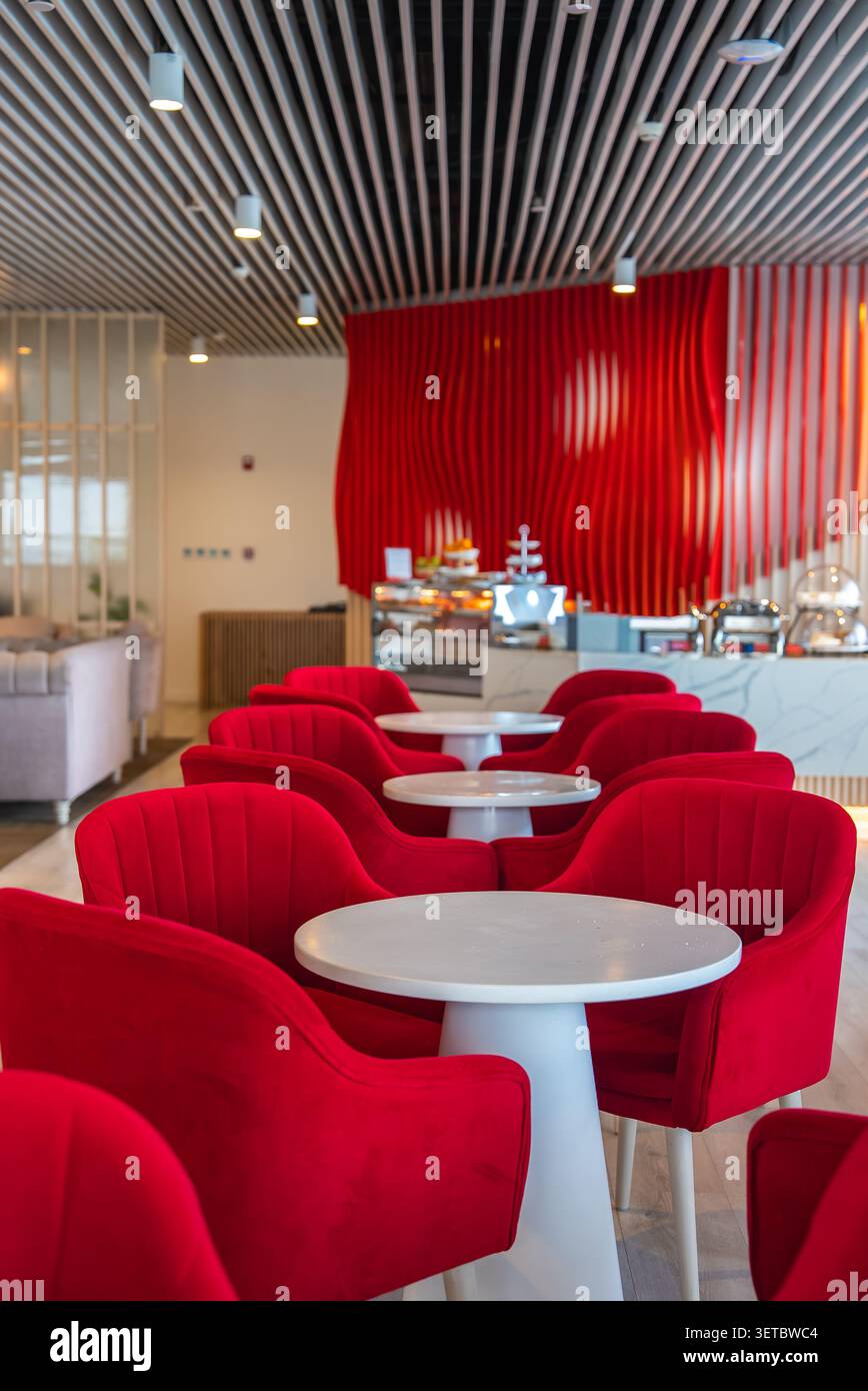 Premium-Lounge mit roten Sesseln und Buffet in Male, Malediven Stockfoto