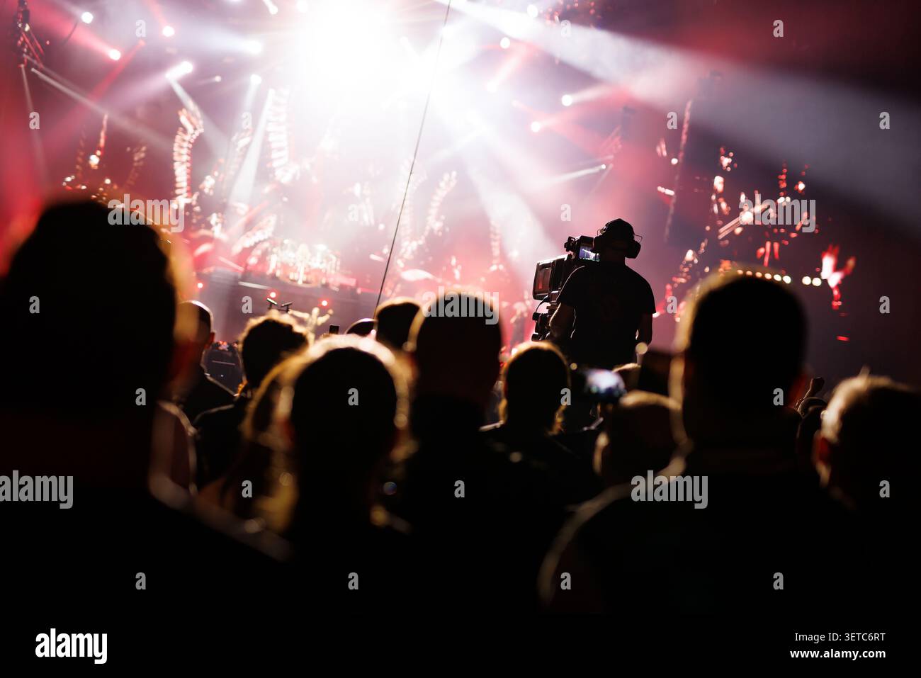Moderator im Schatten hinter einer großen Kamera bei einem Live-Konzert Stockfoto