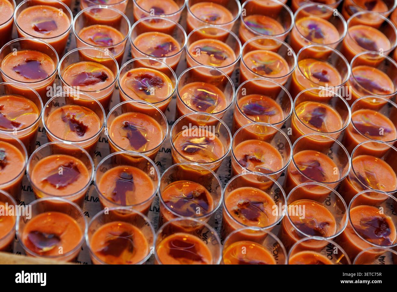 Reihen von Gazpacho-Kaltensuppe-Vorspeisen in Plastiktassen Stockfoto