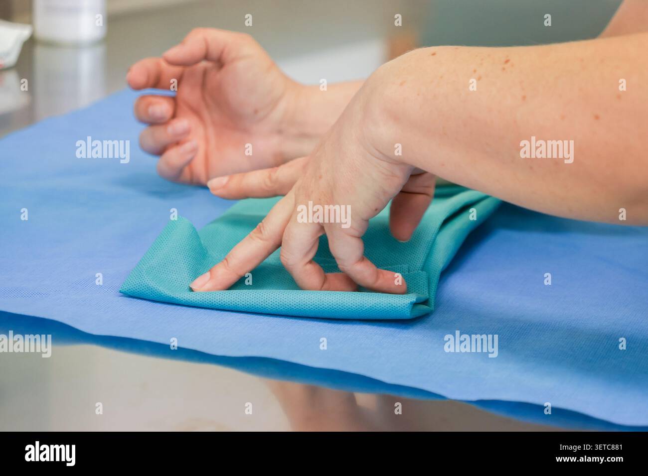 Medizinische Fachkräfte organisieren vor einer Operation steriles Tuch sorgfältig und betonen die Wichtigkeit von Hygiene und sorgfältiger Vorbereitung in m Stockfoto