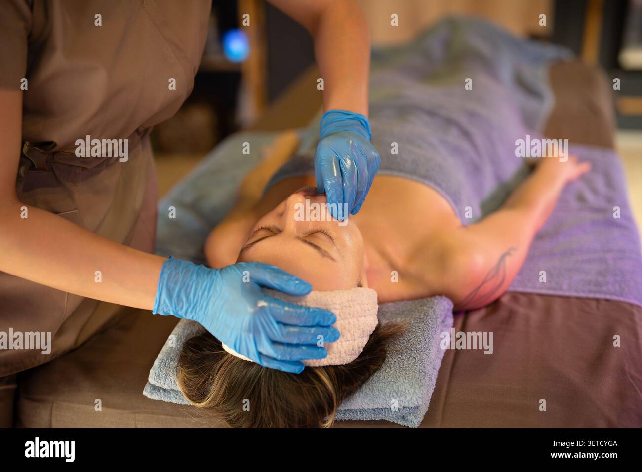 Kosmetologe bei der Wangenmassage an der Frau während der Gesichtsbildbehandlung im Spa-Salon. Stockfoto