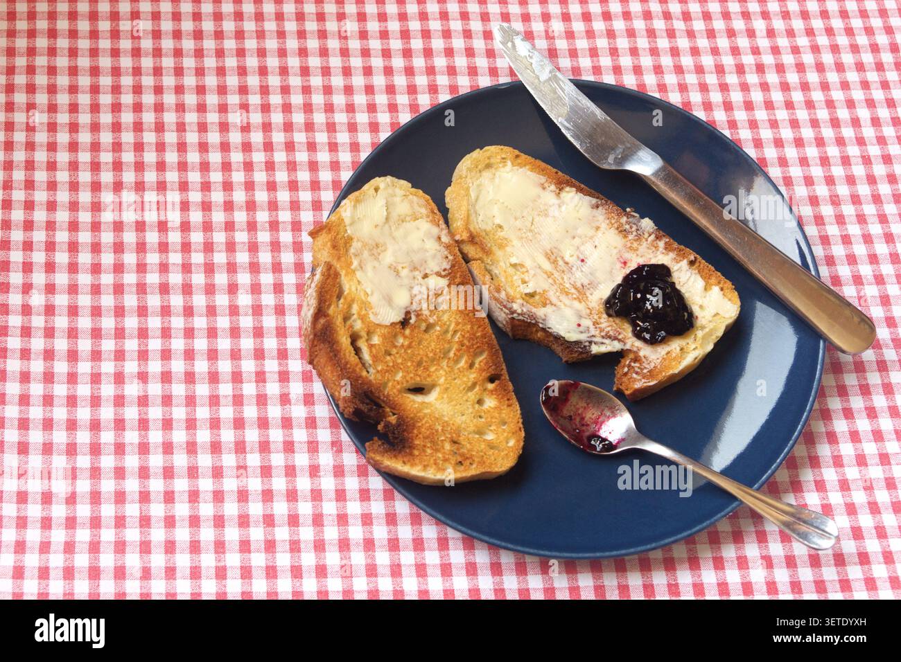Scheiben geröstetes hausgemachtes Brot mit Butter und Heidelbeermarmelade. Stockfoto