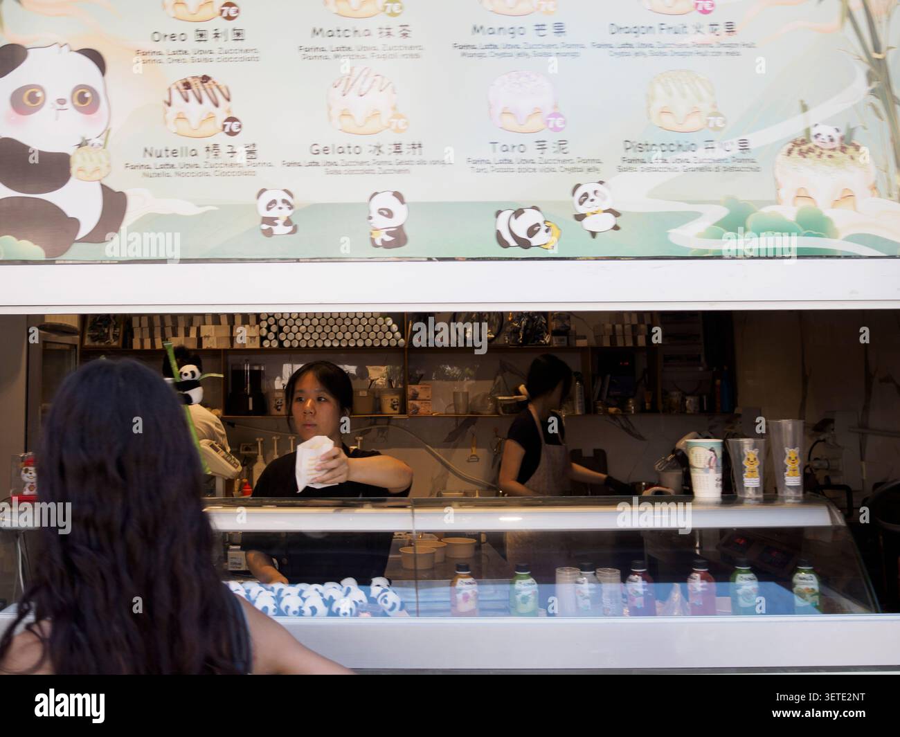 Mailand, Italien 13. Juni 2026 Mitarbeiter, die einen Kunden in einem Panda Roll Dessert Shop servieren und verschiedene Geschmacksrichtungen wie Oreo, Matcha und Nutella anbieten Stockfoto