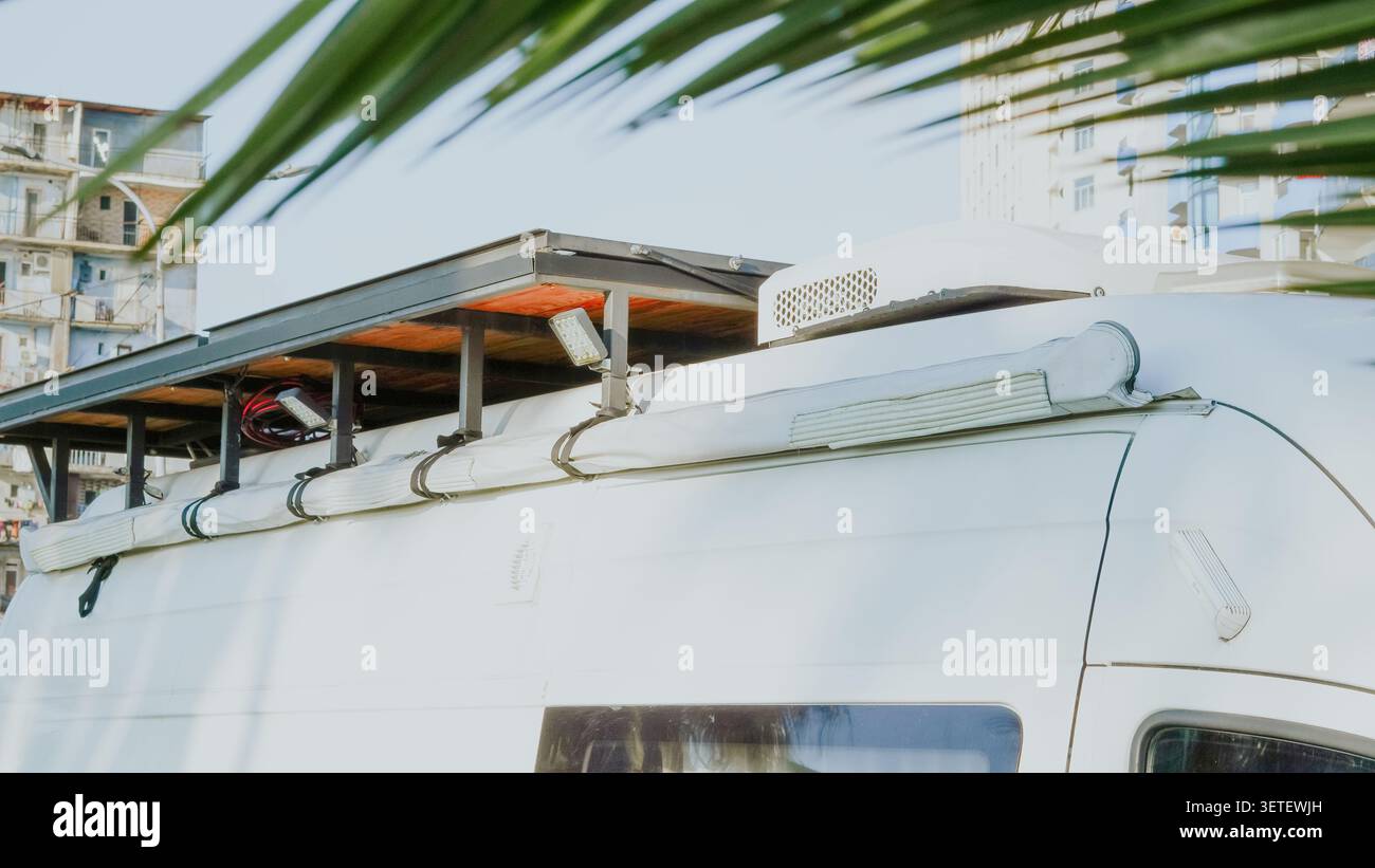 Dachträger und Markise an einem Wohnmobil unter Palmenblättern Stockfoto