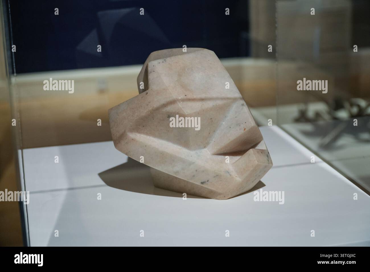 Abstrakte Marmorskulptur mit dem Titel Head Skull des Schweizer Künstlers Alberto Giacometti, ausgestellt in einem Glaskoffer. Stockfoto