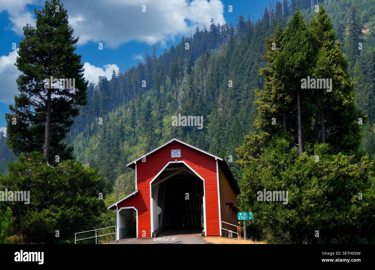 Office Covered Bridge, auch bekannt als Westfir Covered Bridge, ist aus Holz und rot lackiert mit weißen Zierleisten. Es gibt einen überdachten Fußgängerweg Stockfoto