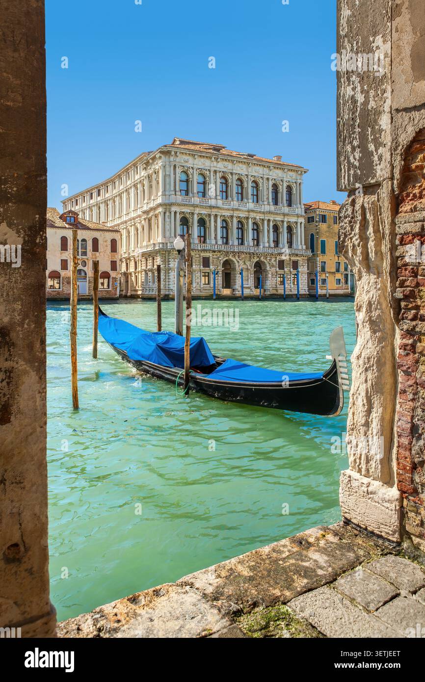 Klassische Aussicht auf den Canal Grande in Venedig mit Gondel und Ca' Pesaro, eingerahmt von einem Torbogen Stockfoto