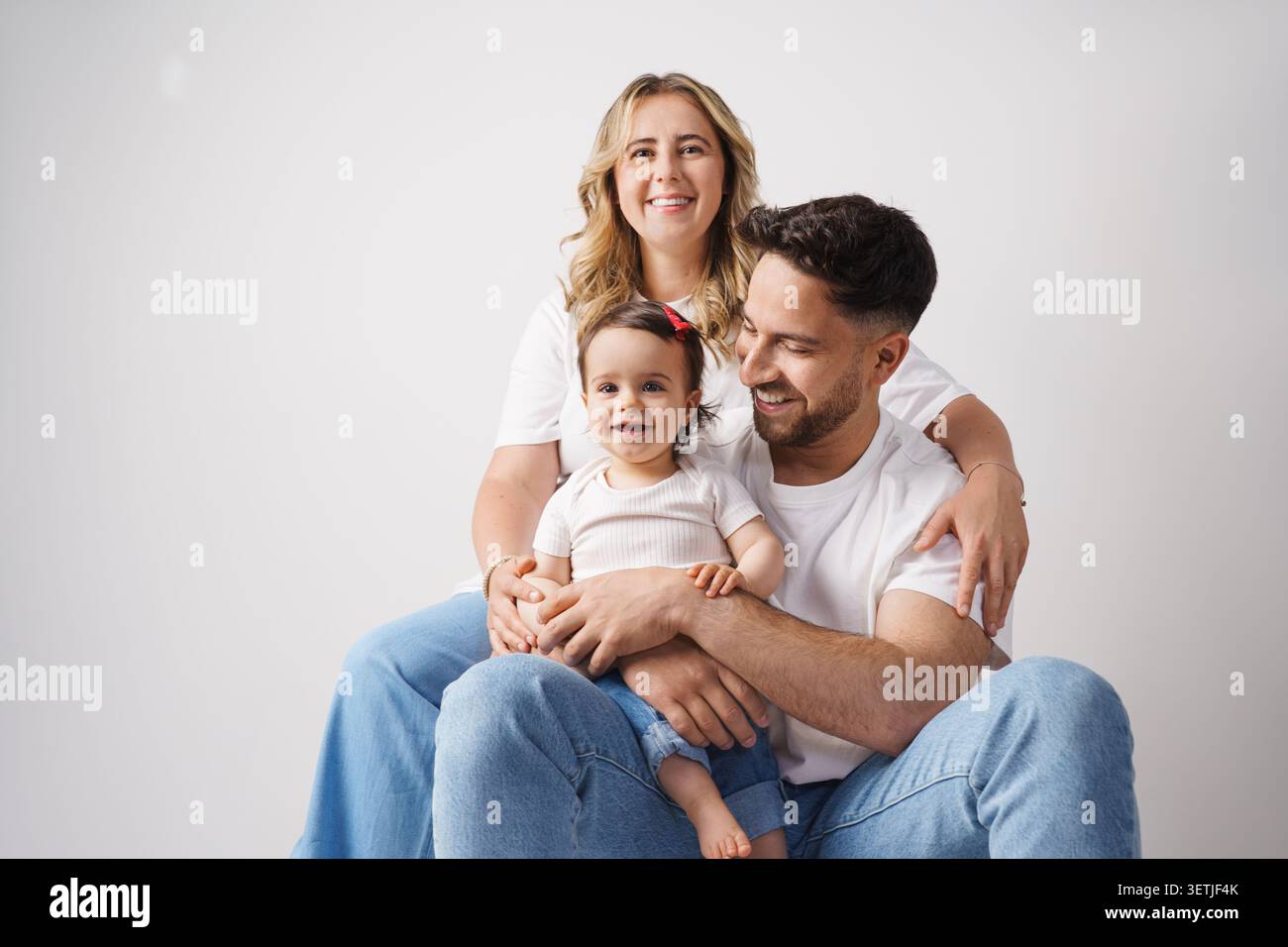 Glückliche Familie, die zusammen in einem modernen Wohnzimmer sitzt Stockfoto