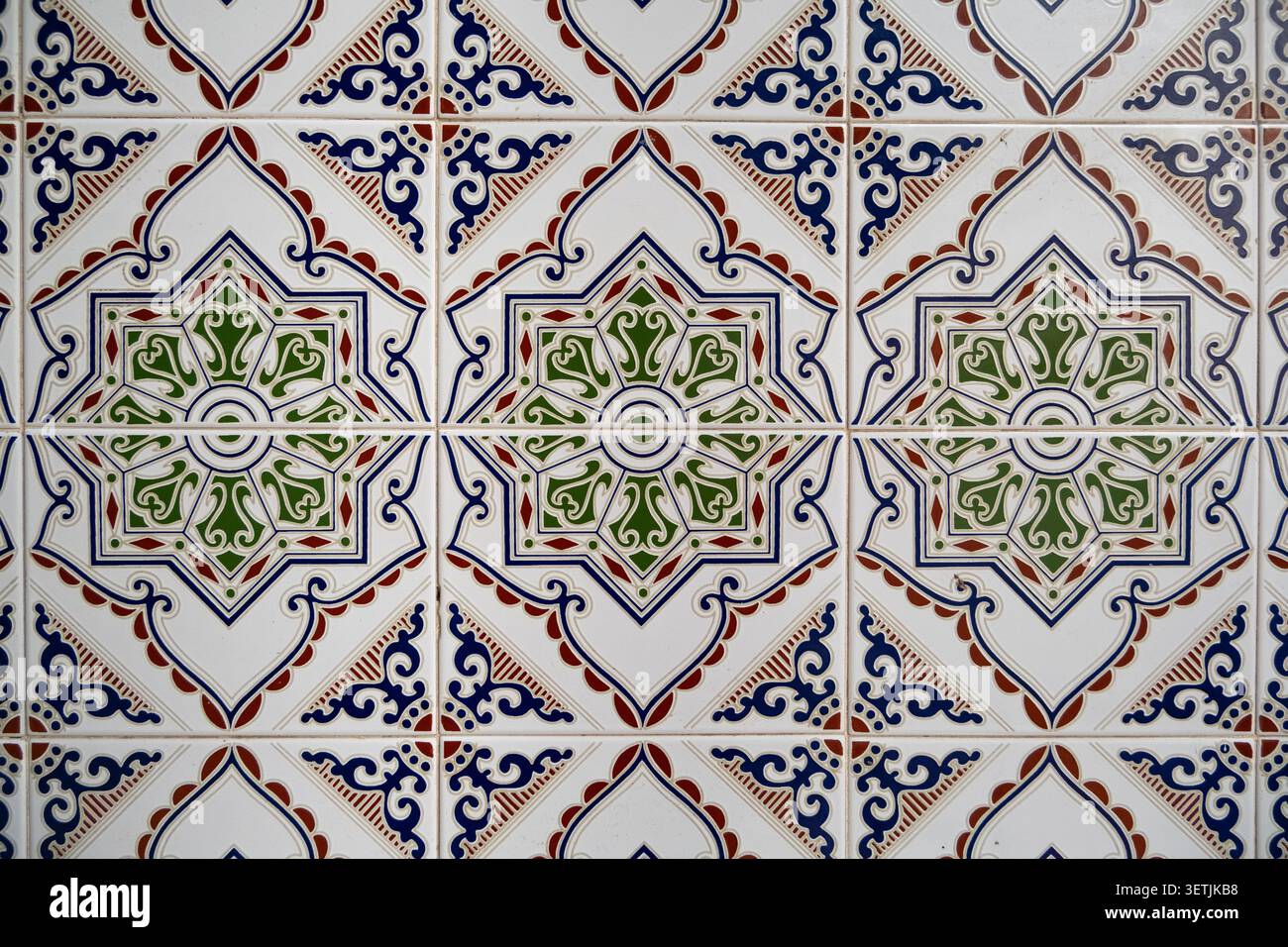 Traditionelle handbemalte Keramikfliesen mit komplexen geometrischen Blumenmustern auf einer hellen Wand, die eine zeitlose mediterrane Ae einfangen Stockfoto