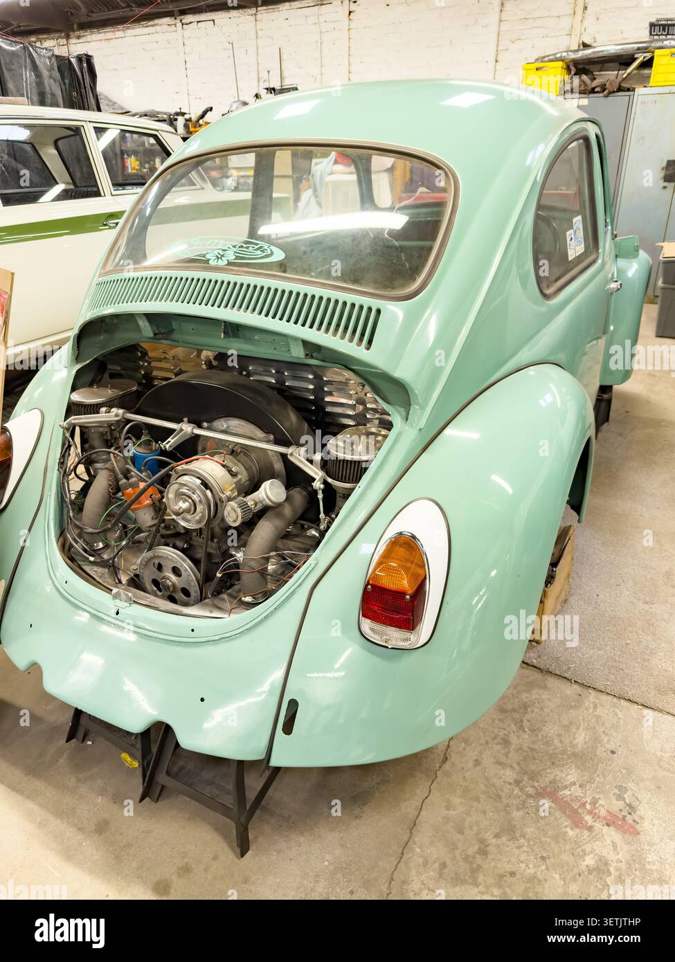 Mintgrüner volkswagen-Käfer, der in einer Werkstatt instandgesetzt und gewartet wird Stockfoto