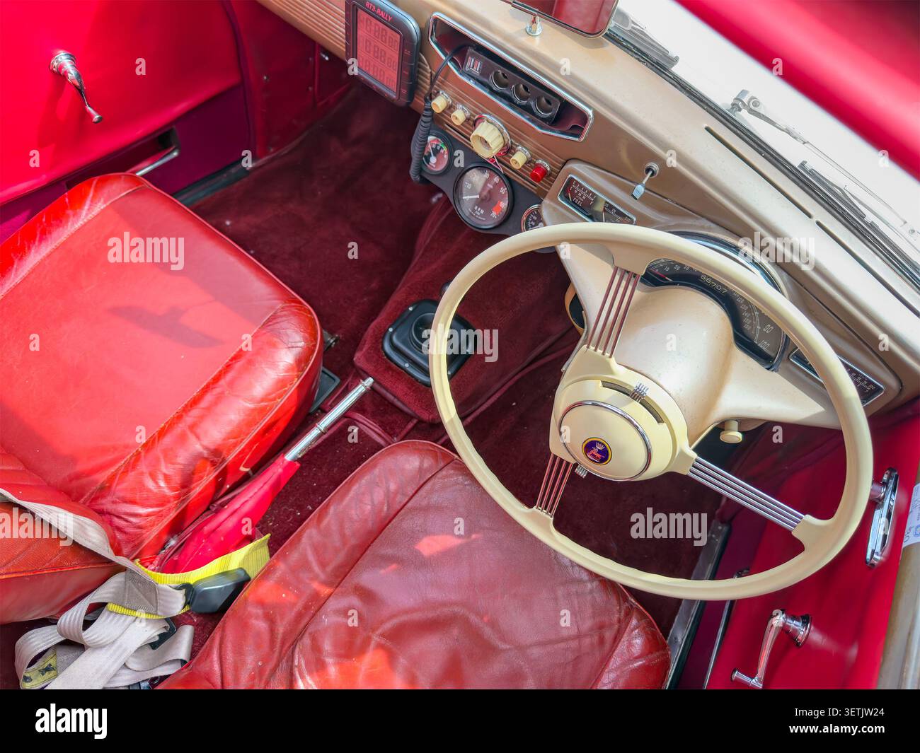 Innenraum einer Vintage Sunbeam talbot 90 Limousine mit roter Lederpolsterung und einem cremefarbenen Lenkrad - Smartphone-aufgenommenes Stockfoto