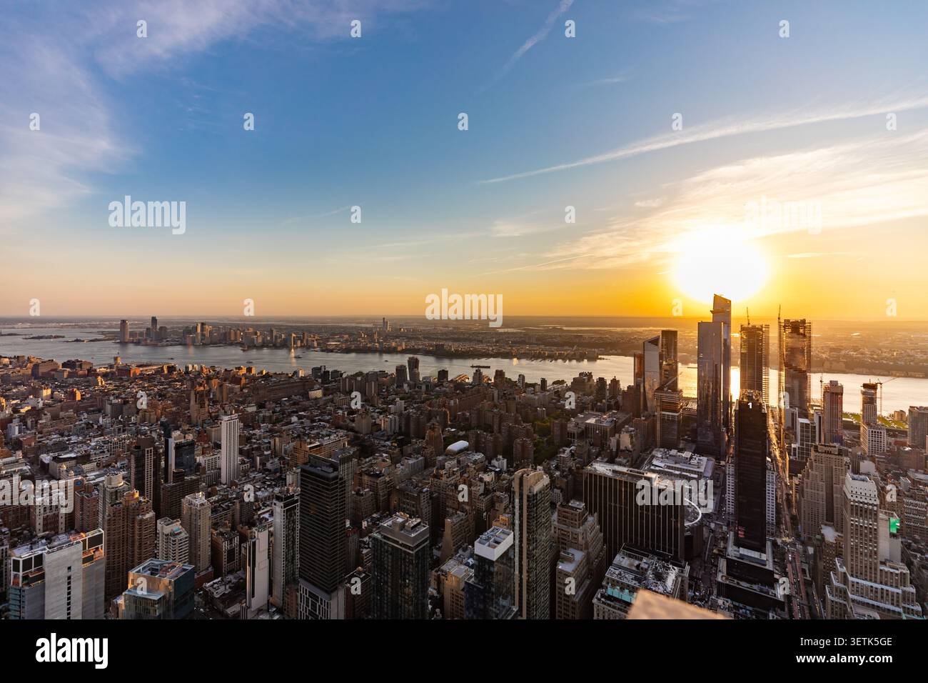 Blick auf die Skyline von New York City bei Sonnenuntergang mit Wolkenkratzern, dem Hudson River und goldenem Licht über die urbane Landschaft in New York, New York, Unite Stockfoto