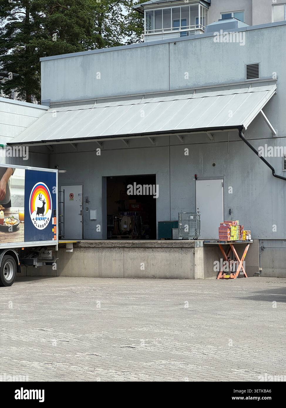Der Polarbröd-Lieferwagen parkte während der Entladung hinter einem Coop-Geschäft und unterstützt die Einzelhandelslogistik und den Lebensmittelvertrieb. - Smartphone-aufgenommenes Stockfoto