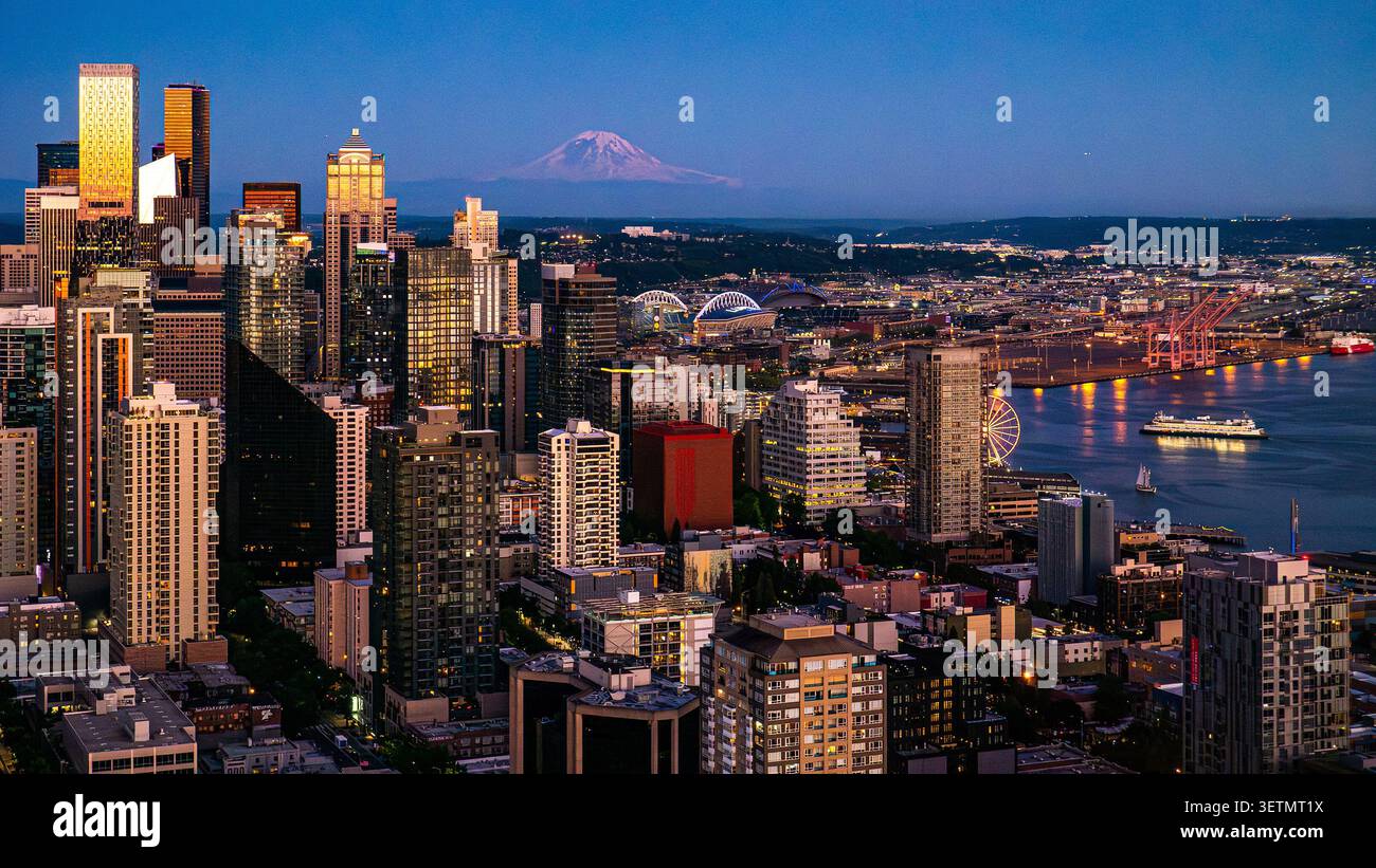Luftaufnahme von Seattle, Washington, Skyline in der Abenddämmerung, mit Wolkenkratzern in der Innenstadt und Mount Rainier am Abend Stockfoto