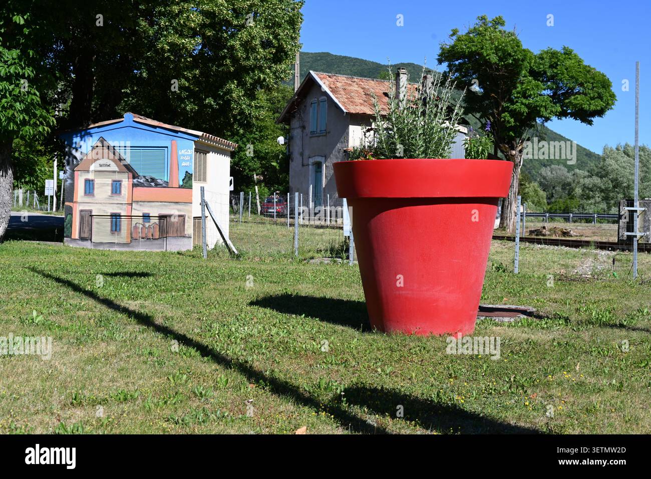 Riesiger roter Plastikpflanzkübel oder Topf und Wandgemälde der Lavendeldestillerie und des Museums Barreme Provence Frankreich Stockfoto