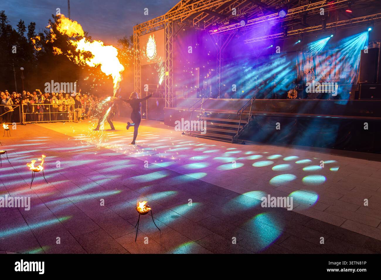 Borovichi, Russland - 5. Juli 2025: Tanzende Feuershow-Künstler bei spektakulärer nächtlicher Performance in dramatischem Licht, feurigen Bewegungen unter dem Nachthimmel, s Stockfoto