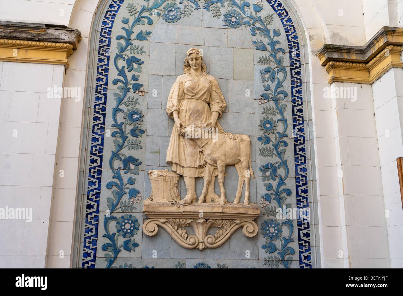 Architektonisches Bas Relief Des Weiblichen Bauern Mit Kalb Auf Dekorativem Mosaikwand Hintergrund Gebäude. Kiew, Ukraine - 23. Mai 2026 Stockfoto