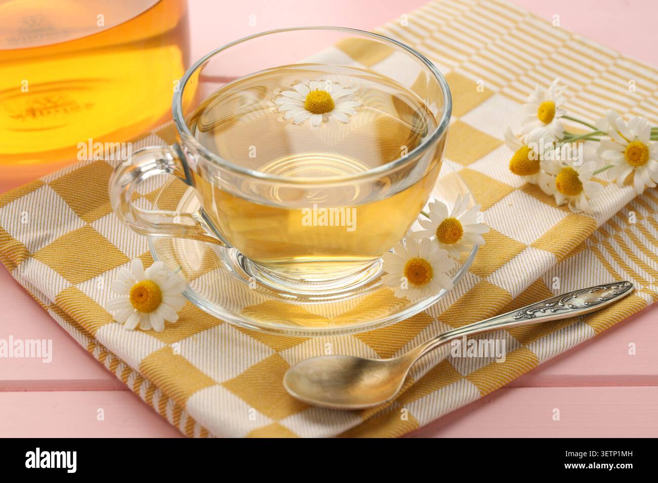 Tasse aromatischen Kamillentee und Blumen auf rosa Holztisch, Nahaufnahme Stockfoto