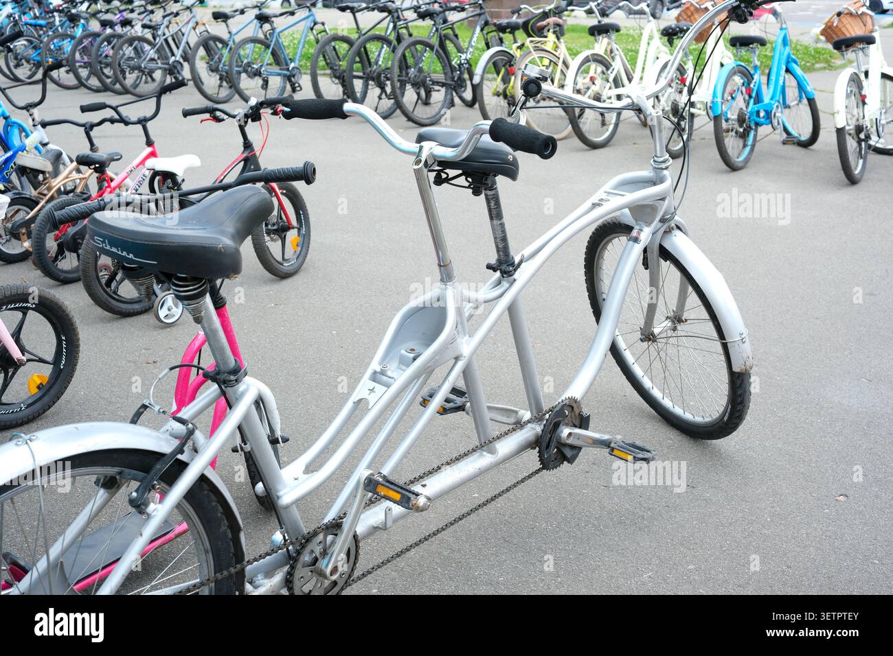 Das Zweisitzer-Tandemfahrrad zeichnet sich durch einen belebten Parkplatz mit Fahrrädern aus. Kiew, Ukraine, 23. Juni 2026 Stockfoto