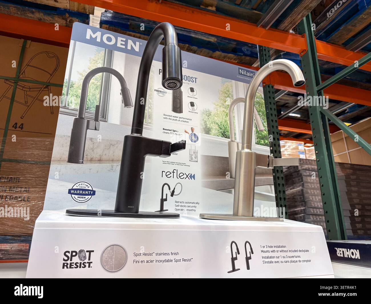 Zwei Moen Küchenarmaturen, ein mattschwarzer und ein Edelstahlhahn, zum Verkauf auf einem Vorführregal. Stockfoto