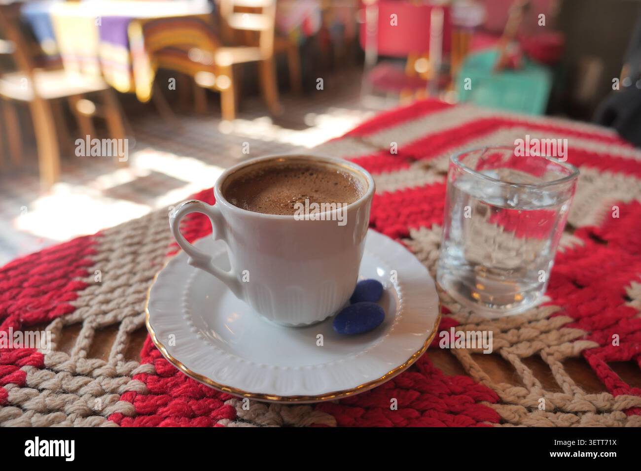Türkischer Kaffee serviert mit einem Glas Wasser auf einem Tisch in einem Café Stockfoto