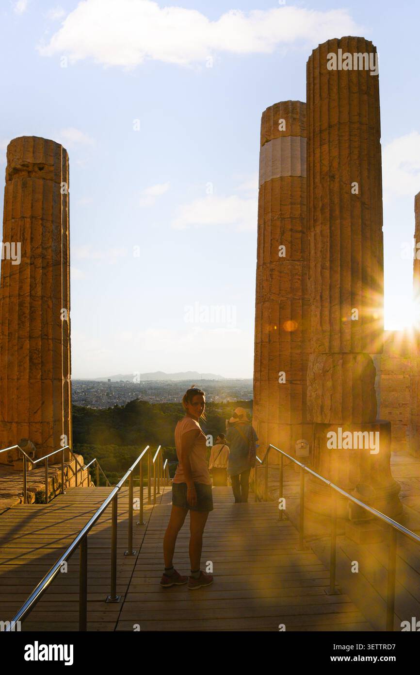 Frau, die Akropolis-Ruinen in Athen bei Sonnenuntergang erkundet Stockfoto