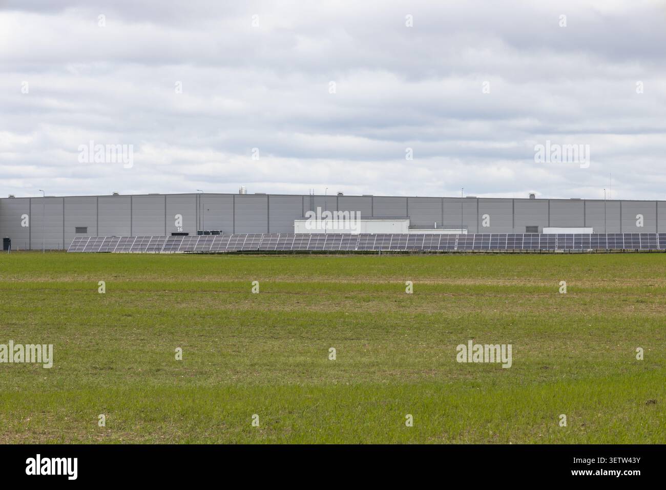 Außenbereich des Industriehauses mit grünem Grasfeld Stockfoto