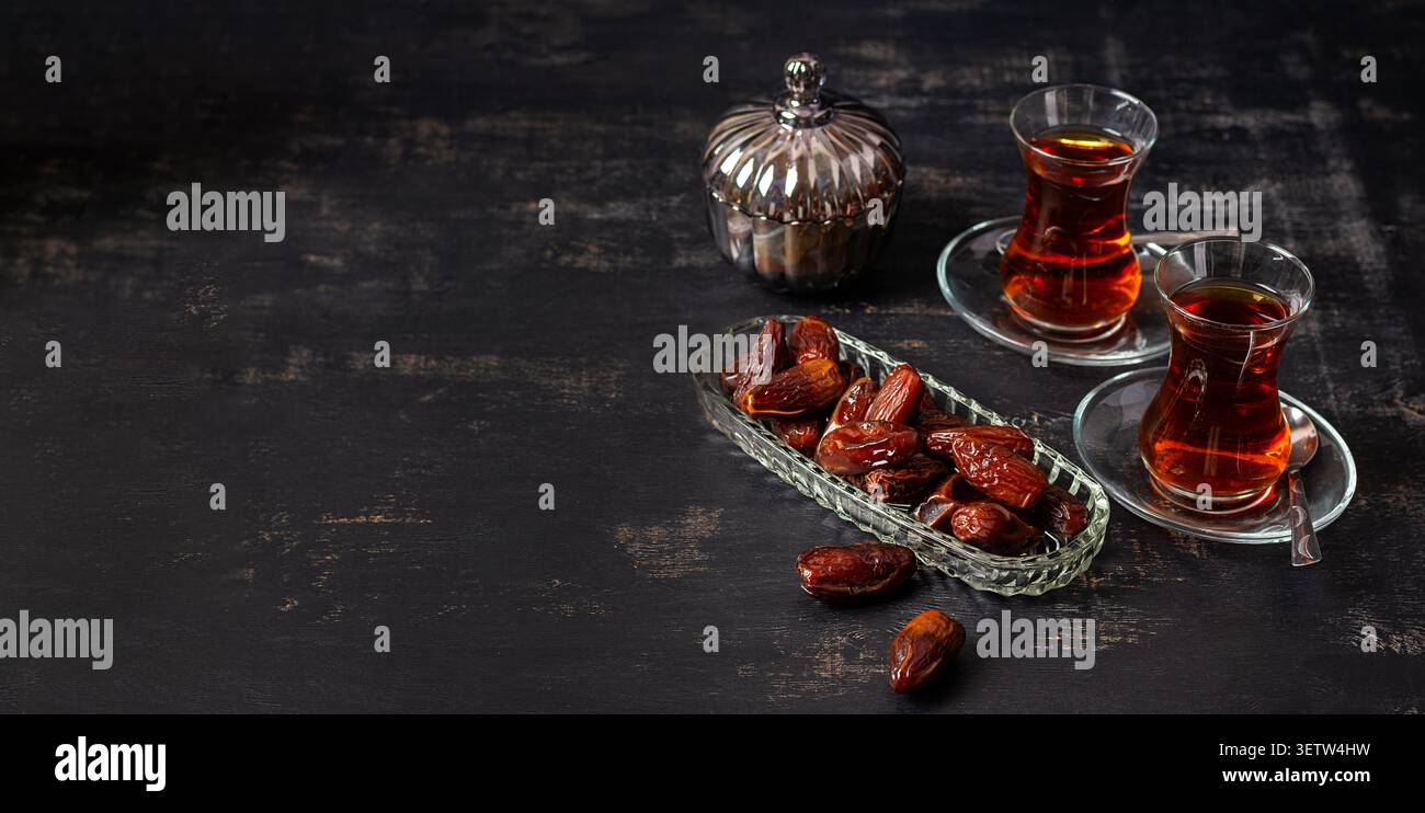 Gesunder natürlicher Snack mit Datteln und schwarzem Tee. Banner Stockfoto