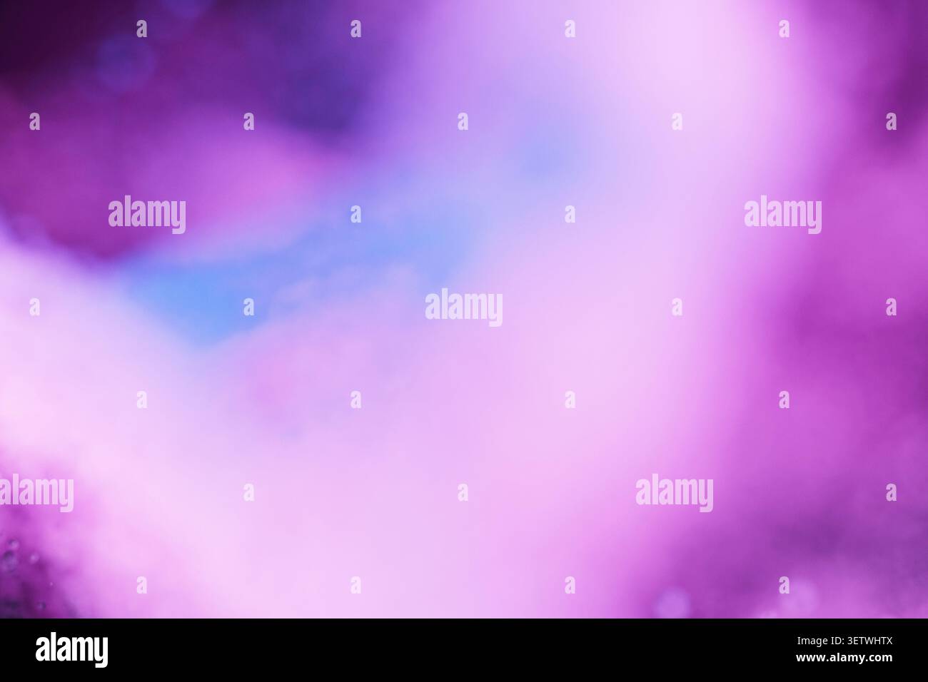 Ein abstrakter, verschwommener Hintergrund mit sanften Neonviolett-, Violett- und heißen Rosa-Tönen mit einem Hauch von Blau. Ätherische rauchige Textur schafft ein traumhaftes, c Stockfoto